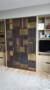 patchwork doors, made from sheets of bronze and brass held together with rivets.
