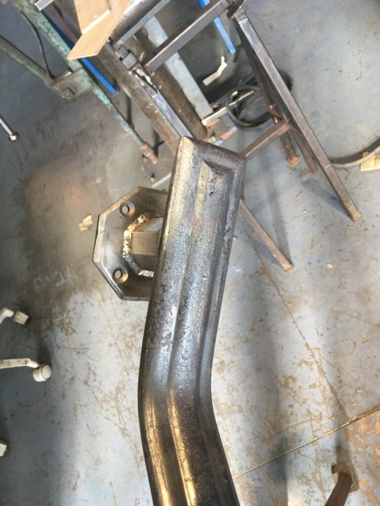 Bent steel rail section joined to a plate on a shop table