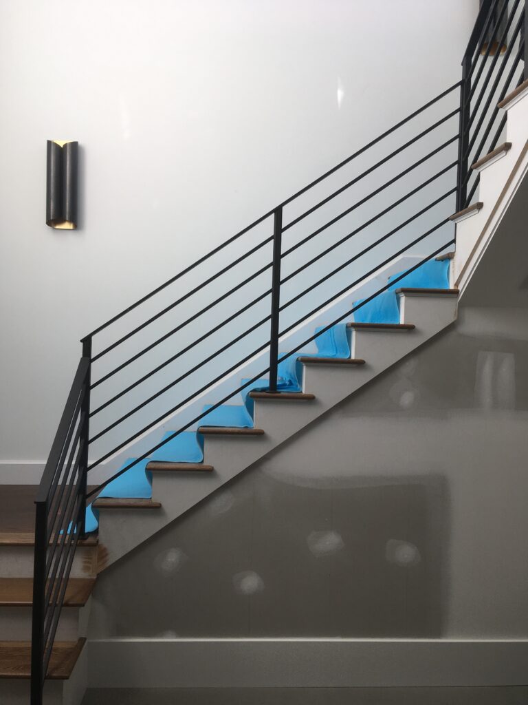 Black horizontal-rod railing along an interior staircase