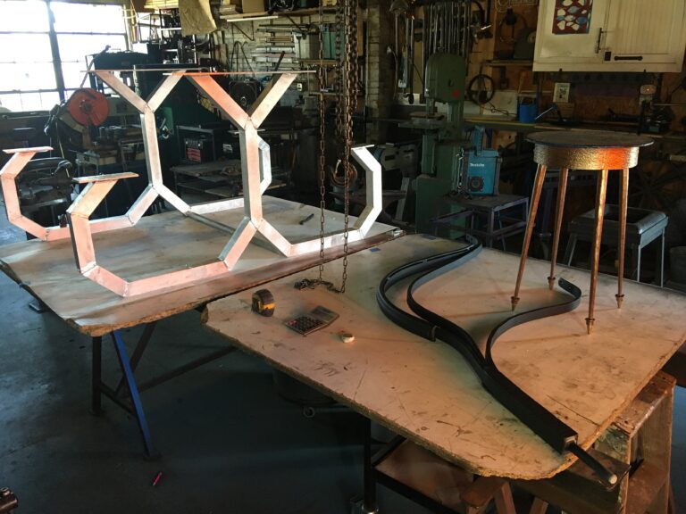 Shop table with a hexagon-pattern metal piece and curved rail sections in progress