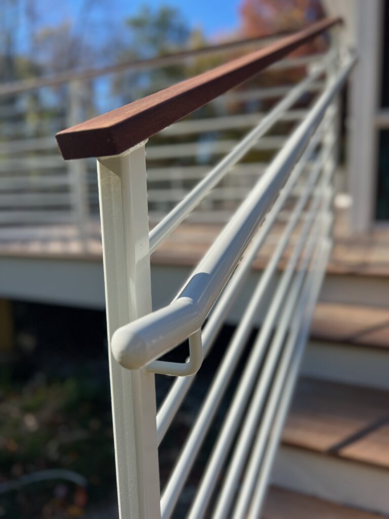 White horizontal-rod guardrail with a wood top rail and a rounded handrail